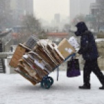 Un hombre empuja un carro con cartones durante una nevada en Seúl, el 16 de febrero de 2016. El banco central de Corea del Sur mantiene sus intereses en un porcentaje récord de 1,5% AFP / Jung Yeon-Je